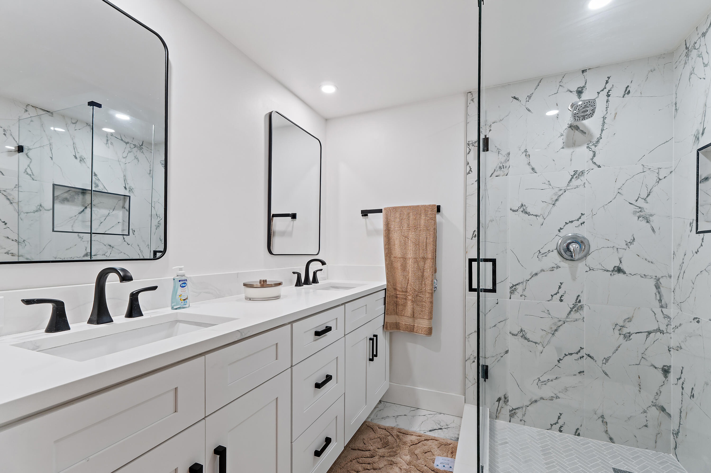 3052 30th Court Jupiter, FL 33477 - Photo 29 of 45 a bathroom with a double vanity sink mirror and shower