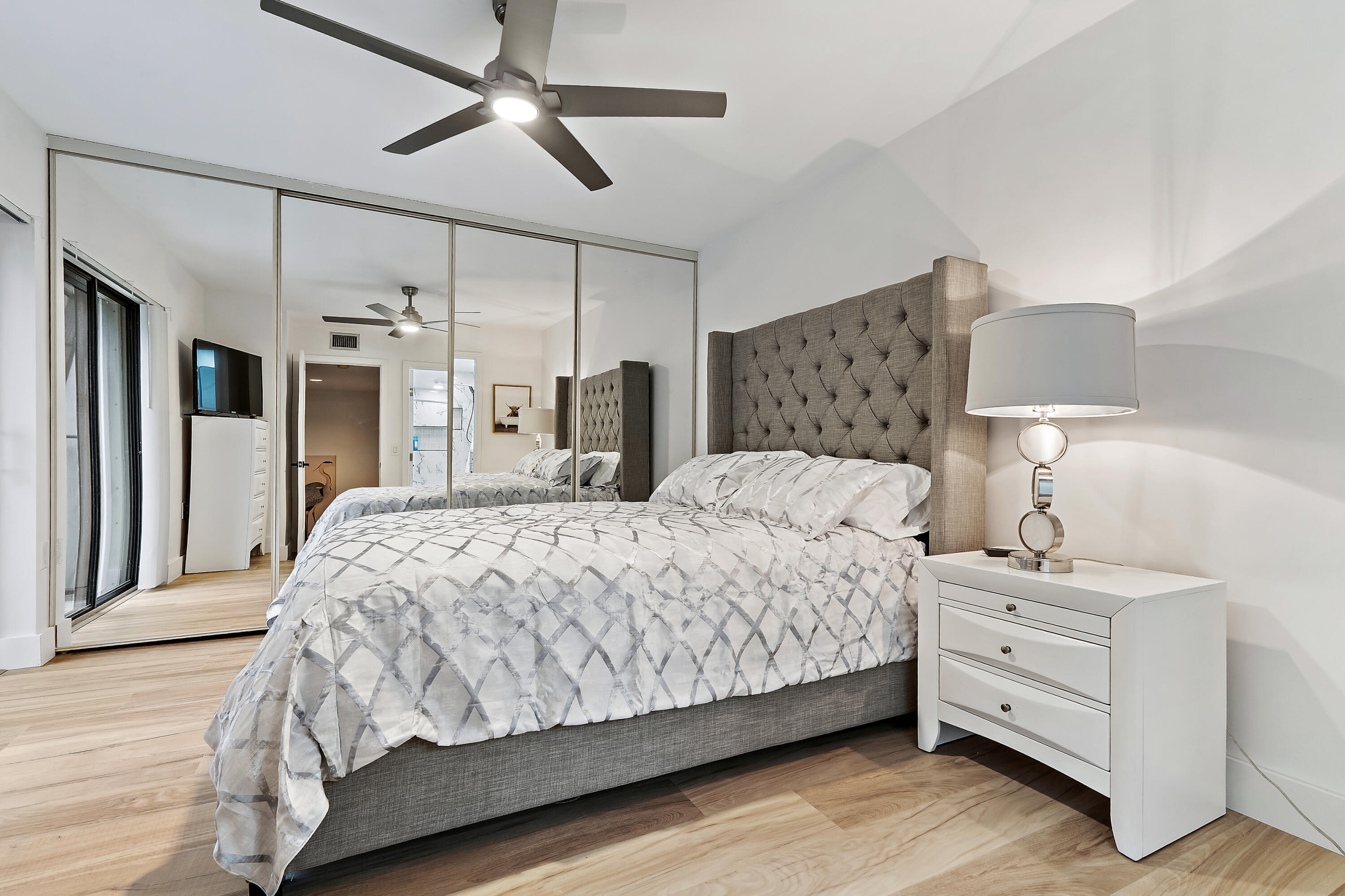 3052 30th Court Jupiter, FL 33477 - Photo 31 of 45 a bedroom with a bed and a lamp on the dresser
