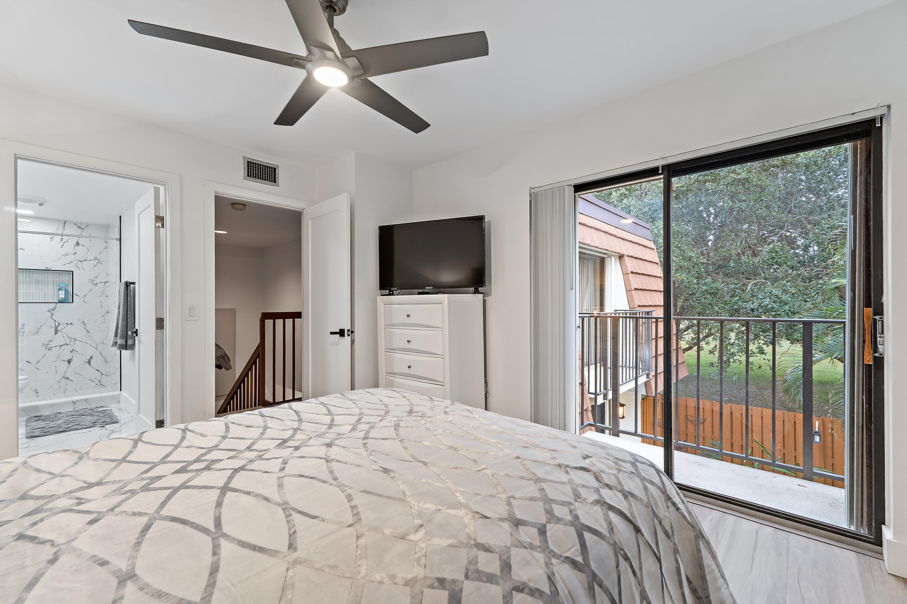3052 30th Court Jupiter, FL 33477 - Photo 33 of 45 a bedroom with a large bed and a flat screen tv
