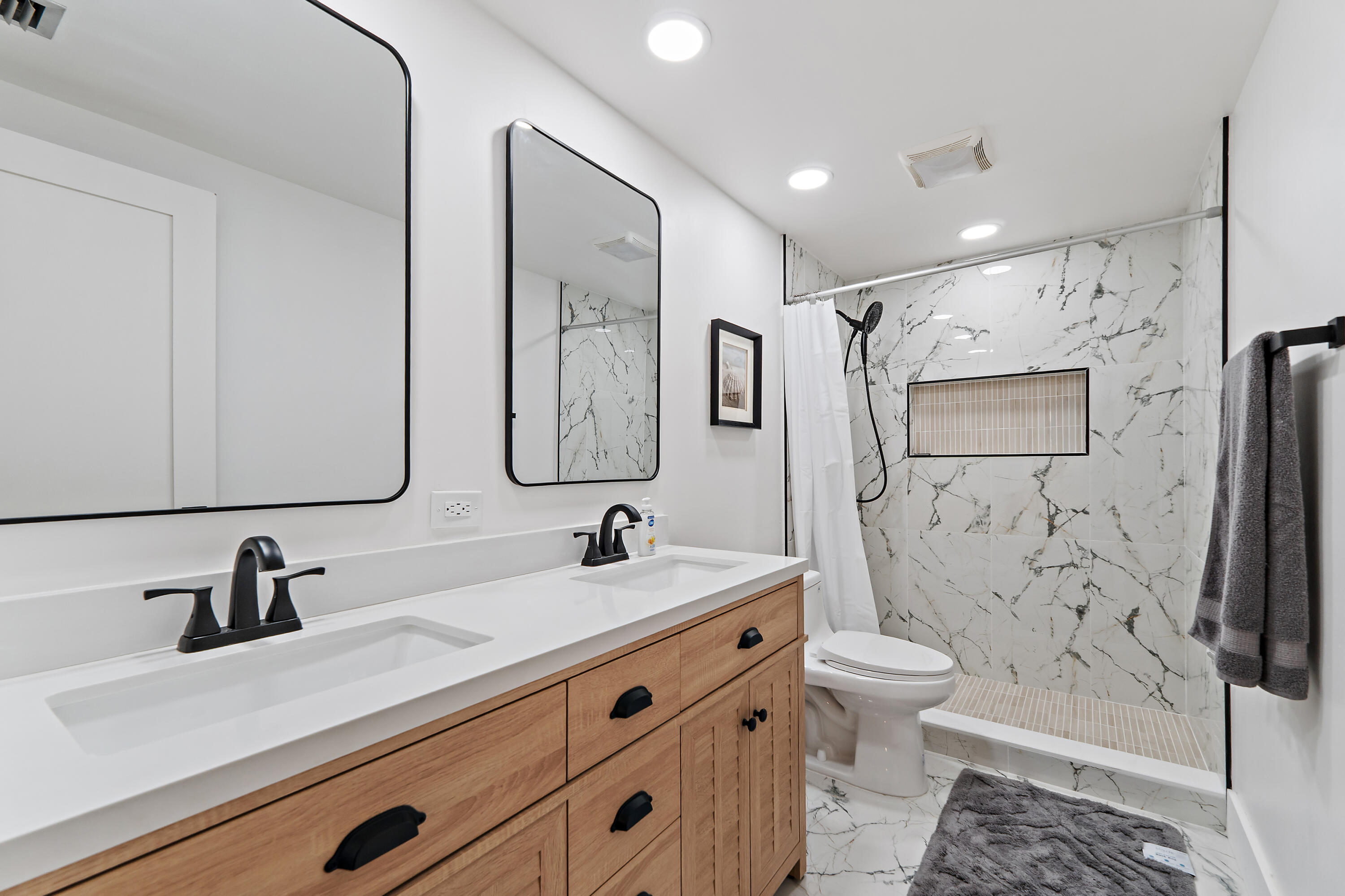 3052 30th Court Jupiter, FL 33477 - Photo 34 of 45 a bathroom with a double vanity sink toilet mirror and shower