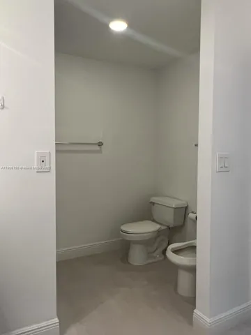 a white toilet sitting next to a shower