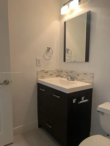 a bathroom with a sink vanity and a mirror