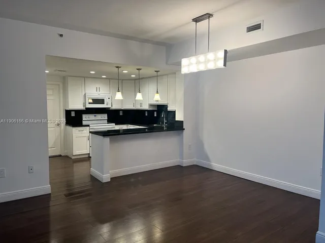 a view of kitchen with cabinets and wooden floor