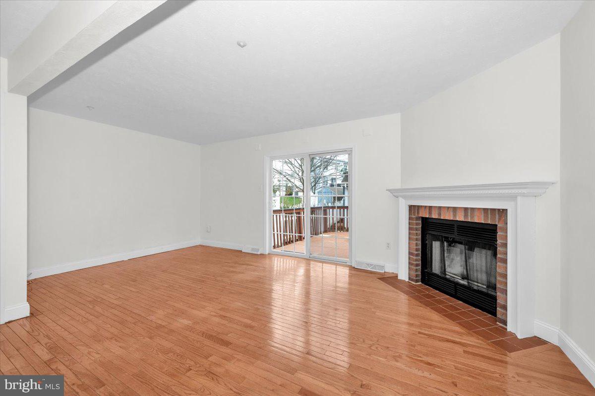 1184 Heathfield Road Sykesville, MD 21784 - Photo 13 of 56 a view of an empty room with wooden floor fireplace and a window