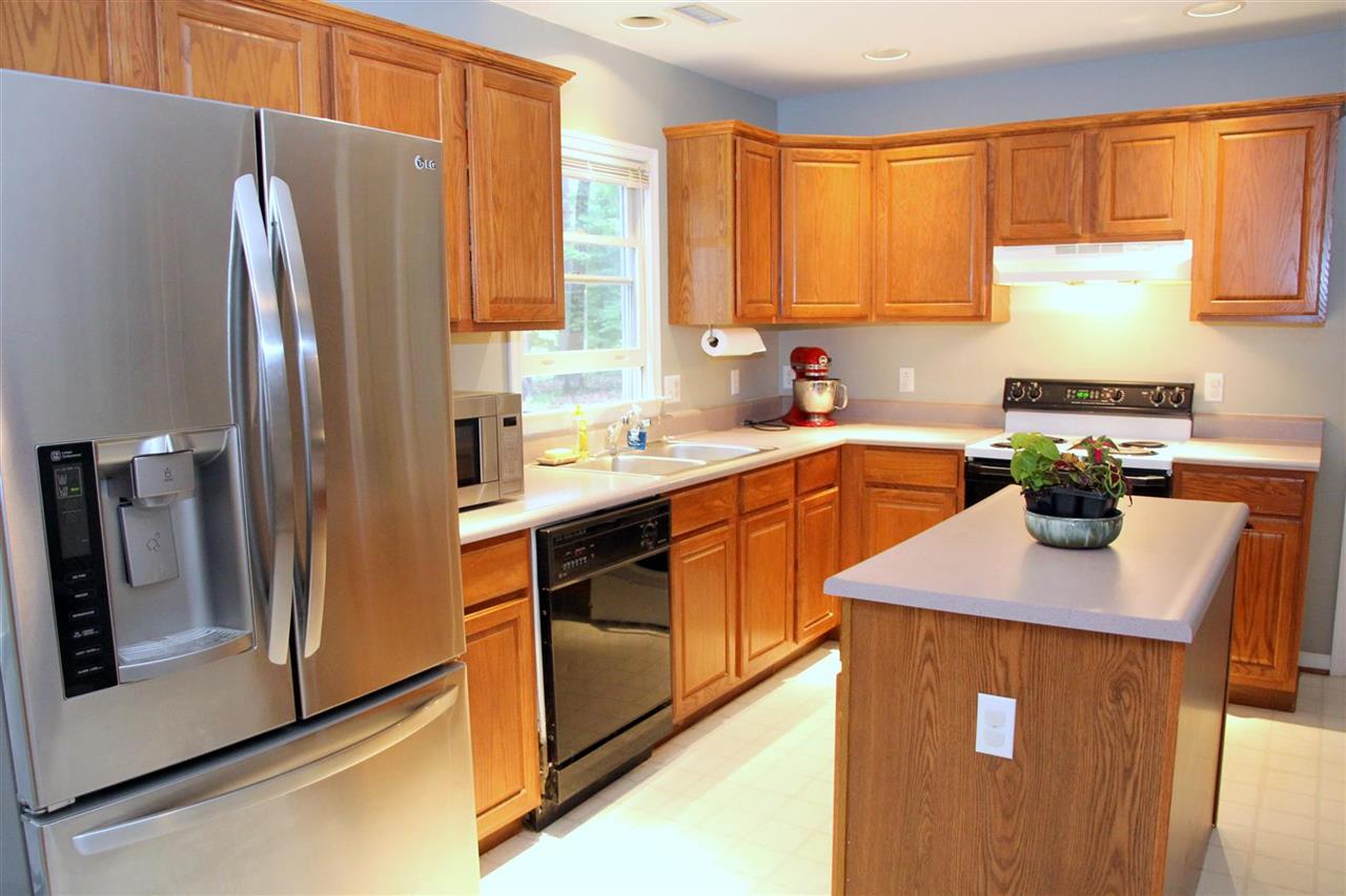 39 Rudolph Street Ruckersville, VA 22968 - Photo 13 of 30 a kitchen with stainless steel appliances granite countertop a refrigerator a sink a stove and white cabinets with wooden floor