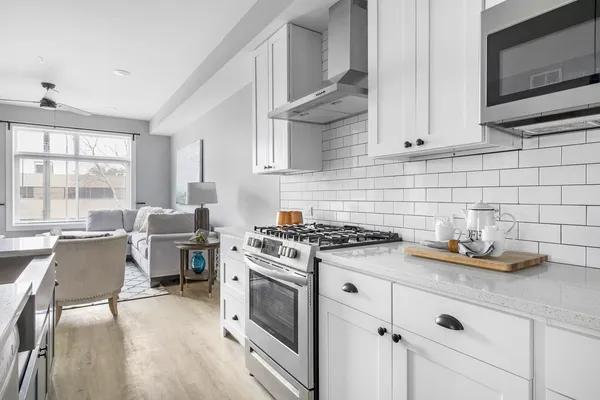 a kitchen with cabinets wooden floor and a stove top oven