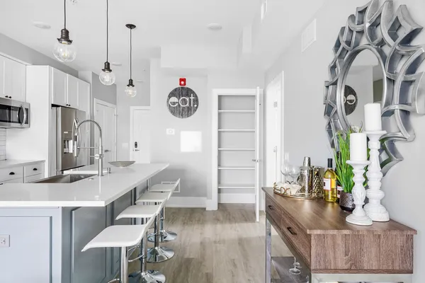 a kitchen with stainless steel appliances kitchen island granite countertop a table chairs in it and wooden floor