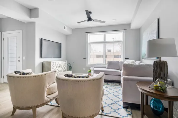 a living room with furniture a flat screen tv and a window