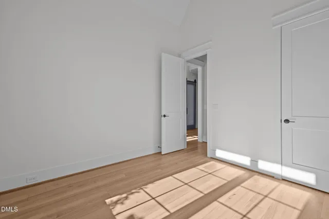 a view of a hallway with wooden floor and windows