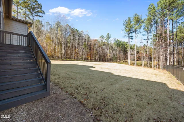 an aerial view of residential house with outdoor space and trees all around