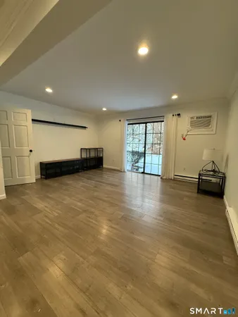 a view of a room with a refrigerator wooden floor and window