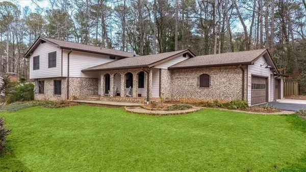 a front view of a house with yard and balcony