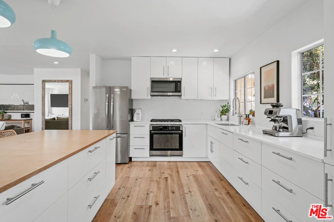 6926 Cedros Avenue Van Nuys, CA 91405 - Photo 12 of 26 a large kitchen with a stove and white cabinets