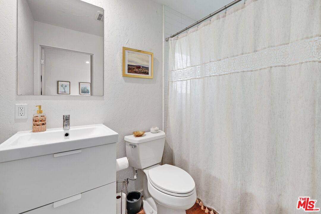 6926 Cedros Avenue Van Nuys, CA 91405 - Photo 24 of 26 a bathroom with a toilet a sink and a mirror