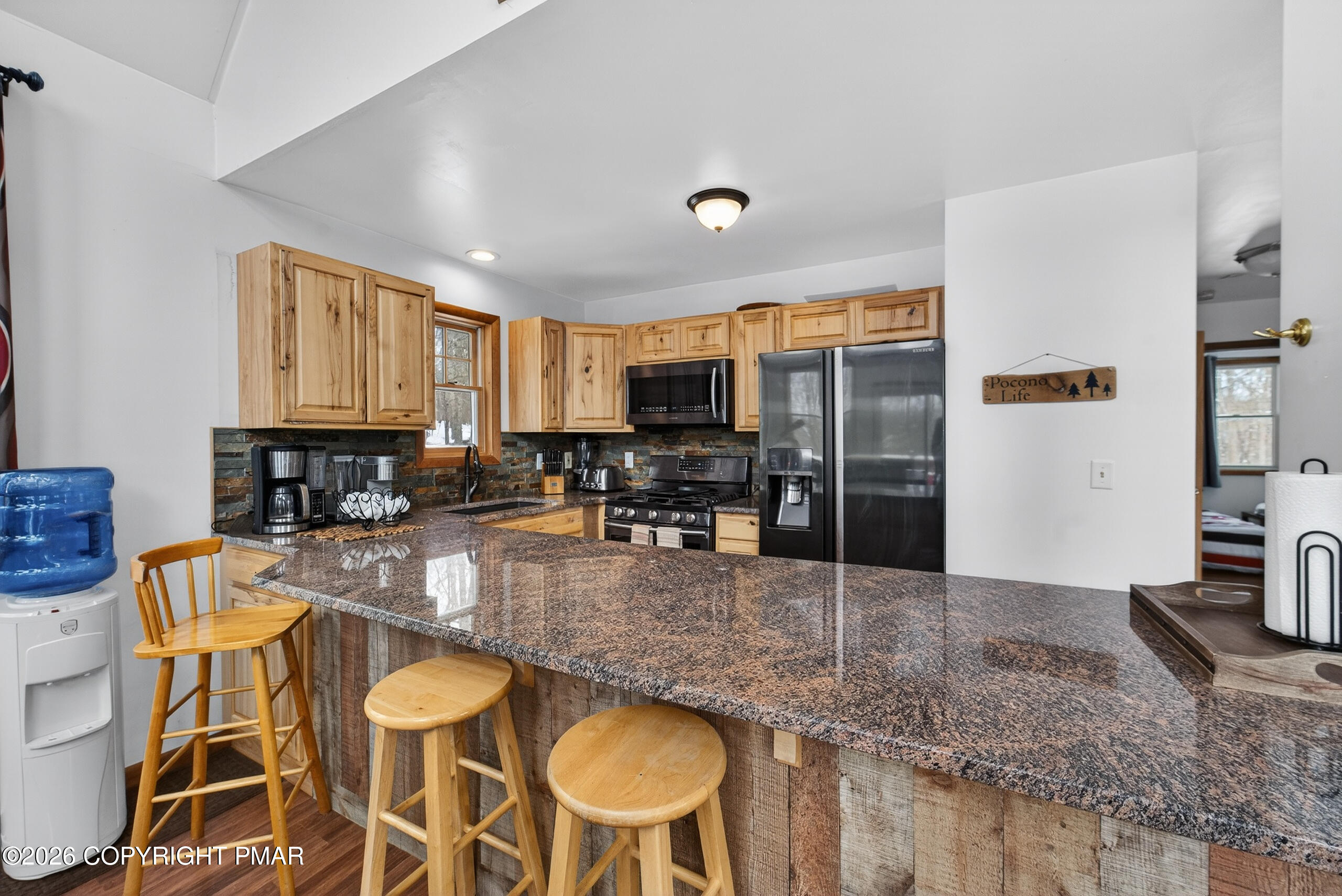 3112 Spring Court Bushkill, PA 18324 - Photo 18 of 52 a kitchen with stainless steel appliances granite countertop a stove top oven a sink a dining table and chairs