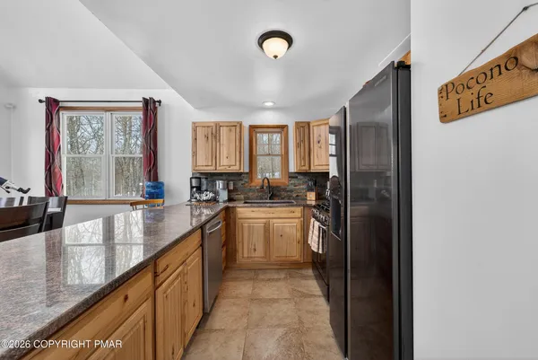 a kitchen with stainless steel appliances granite countertop a refrigerator and a sink