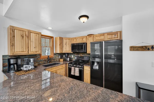 a kitchen with stainless steel appliances granite countertop a refrigerator stove top oven a sink and dishwasher