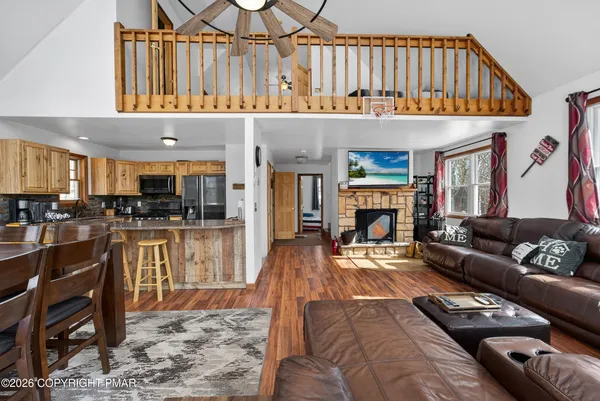 a living room with furniture a fireplace and kitchen view