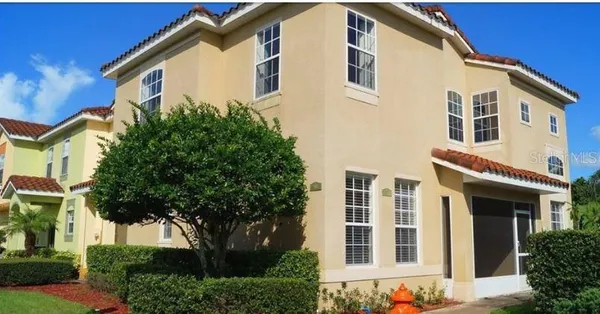 a front view of a house with a tree