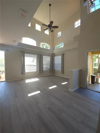 a view of an empty room with window and wooden floor
