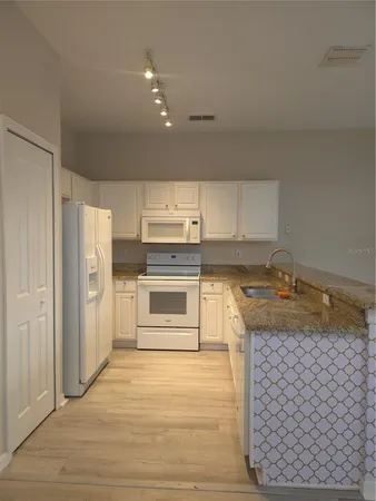 a kitchen with a stove a refrigerator and a sink