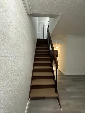 an empty room with wooden floor chandelier fan and windows