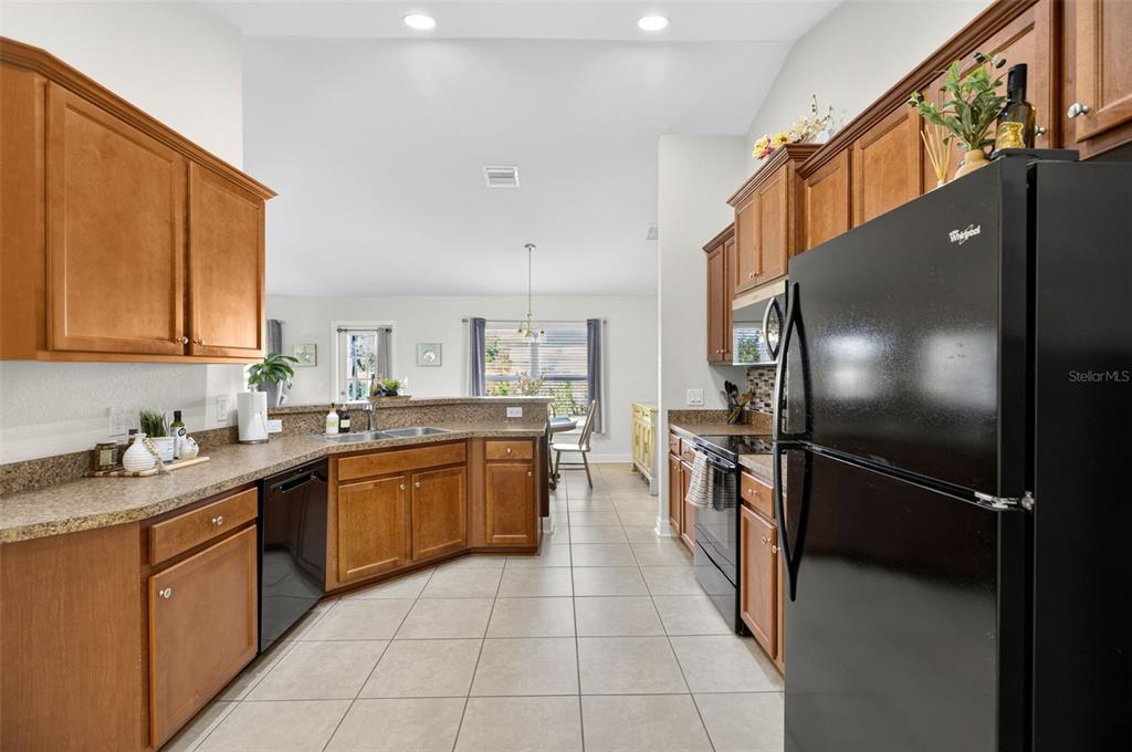 8049 Dimstead Street Port Charlotte, FL 33981 - Photo 12 of 39 a kitchen with stainless steel appliances granite countertop a sink stove and refrigerator