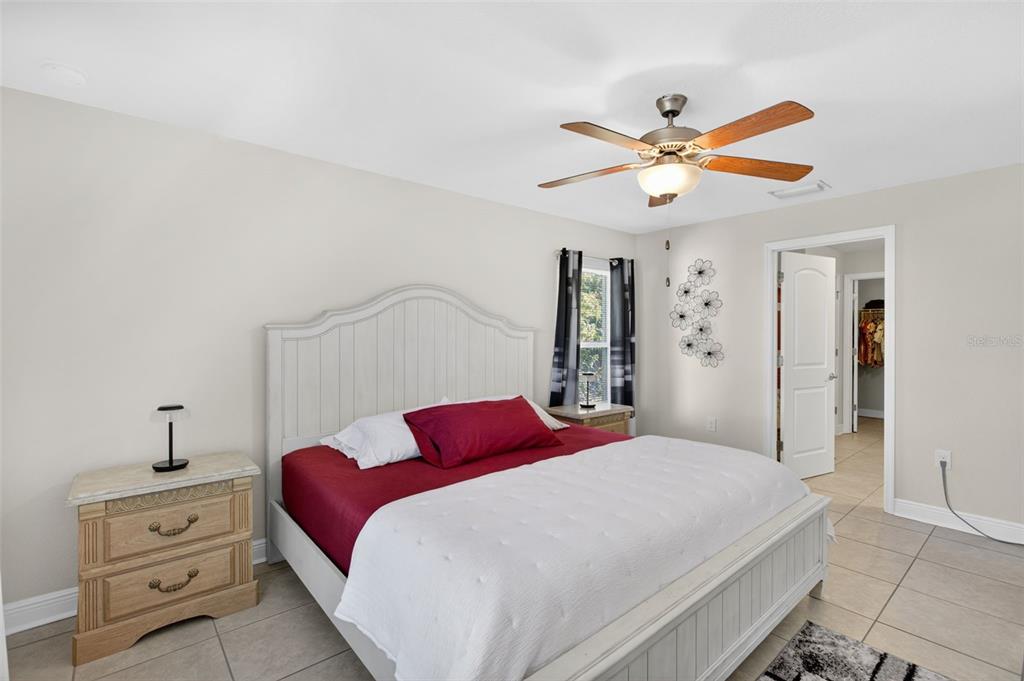 8049 Dimstead Street Port Charlotte, FL 33981 - Photo 19 of 39 a bedroom with a bed and a chandelier