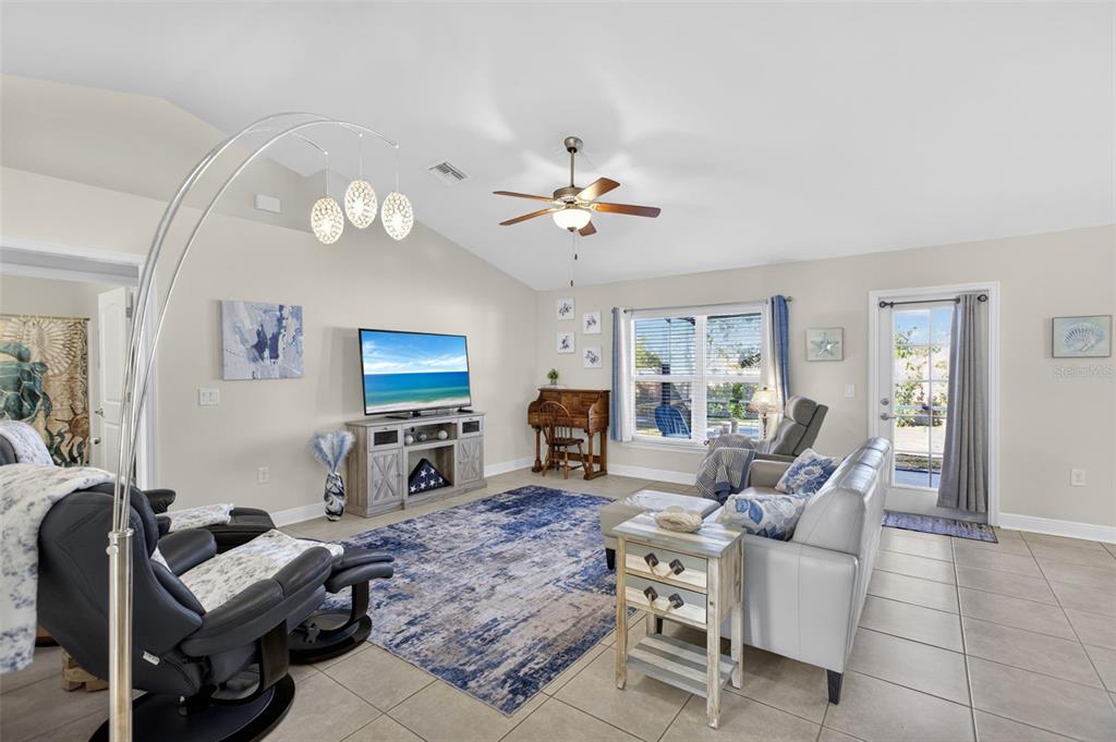 8049 Dimstead Street Port Charlotte, FL 33981 - Photo 5 of 39 a living room with furniture a fireplace and a flat screen tv