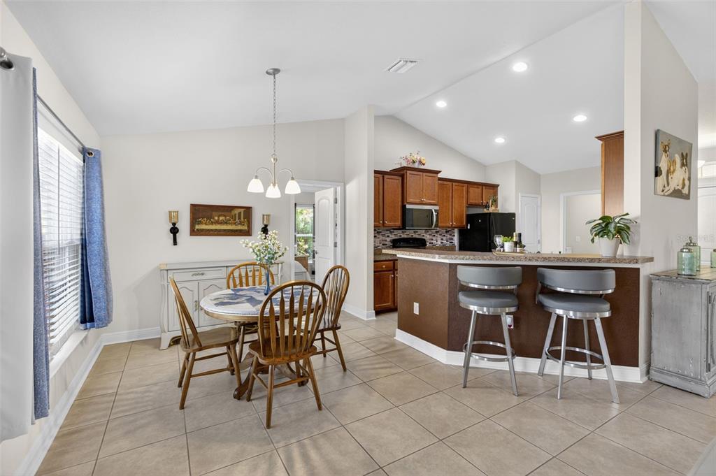 8049 Dimstead Street Port Charlotte, FL 33981 - Photo 8 of 39 a kitchen with stainless steel appliances kitchen island granite countertop a dining table chairs and a refrigerator