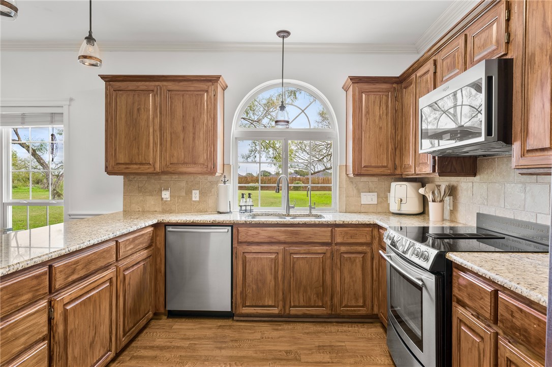 2 Schendel Road Portland, TX 78374 - Photo 12 of 39 a kitchen with stainless steel appliances granite countertop a sink a stove a refrigerator cabinets and a window
