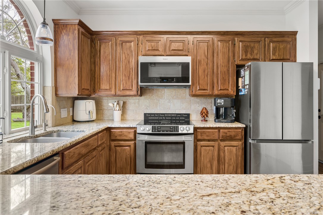 2 Schendel Road Portland, TX 78374 - Photo 13 of 39 a kitchen with granite countertop a refrigerator stove and microwave
