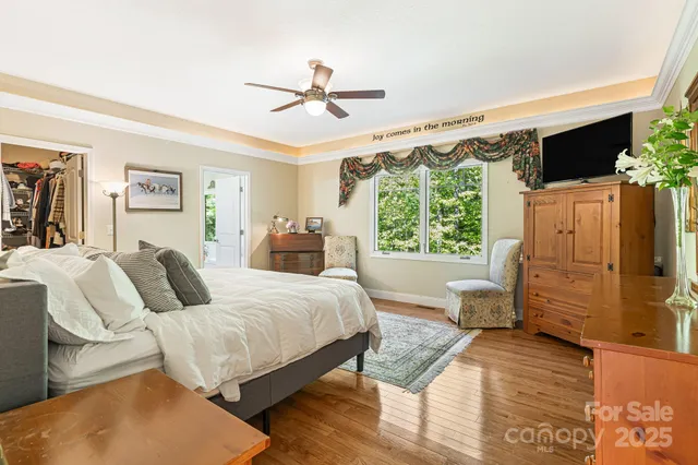 a bedroom with a large bed and a flat tv screen