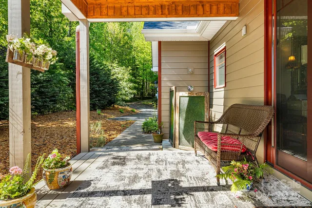 a view of a porch with chairs and potted plants