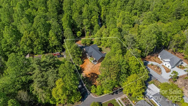 an aerial view of residential house with outdoor space and trees all around