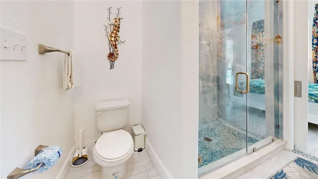 a bathroom with a toilet and a shower