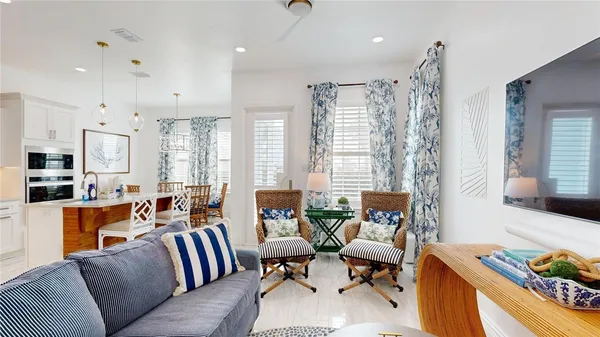 a living room with furniture kitchen view and a large window