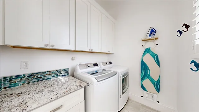 a room with kitchen island white cabinets and a sink