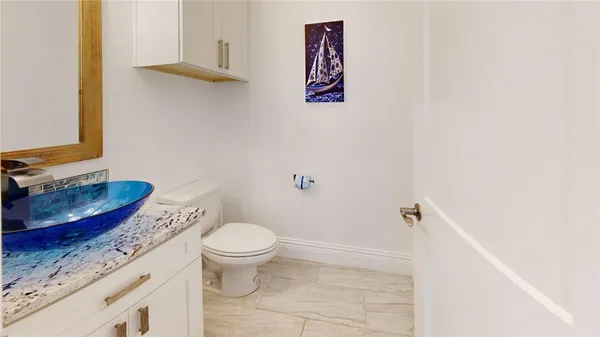 a bathroom with a granite countertop toilet and a sink