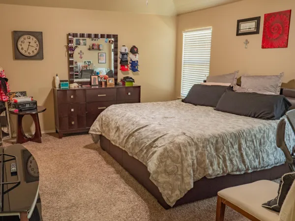 a bedroom with a bed and dresser with window