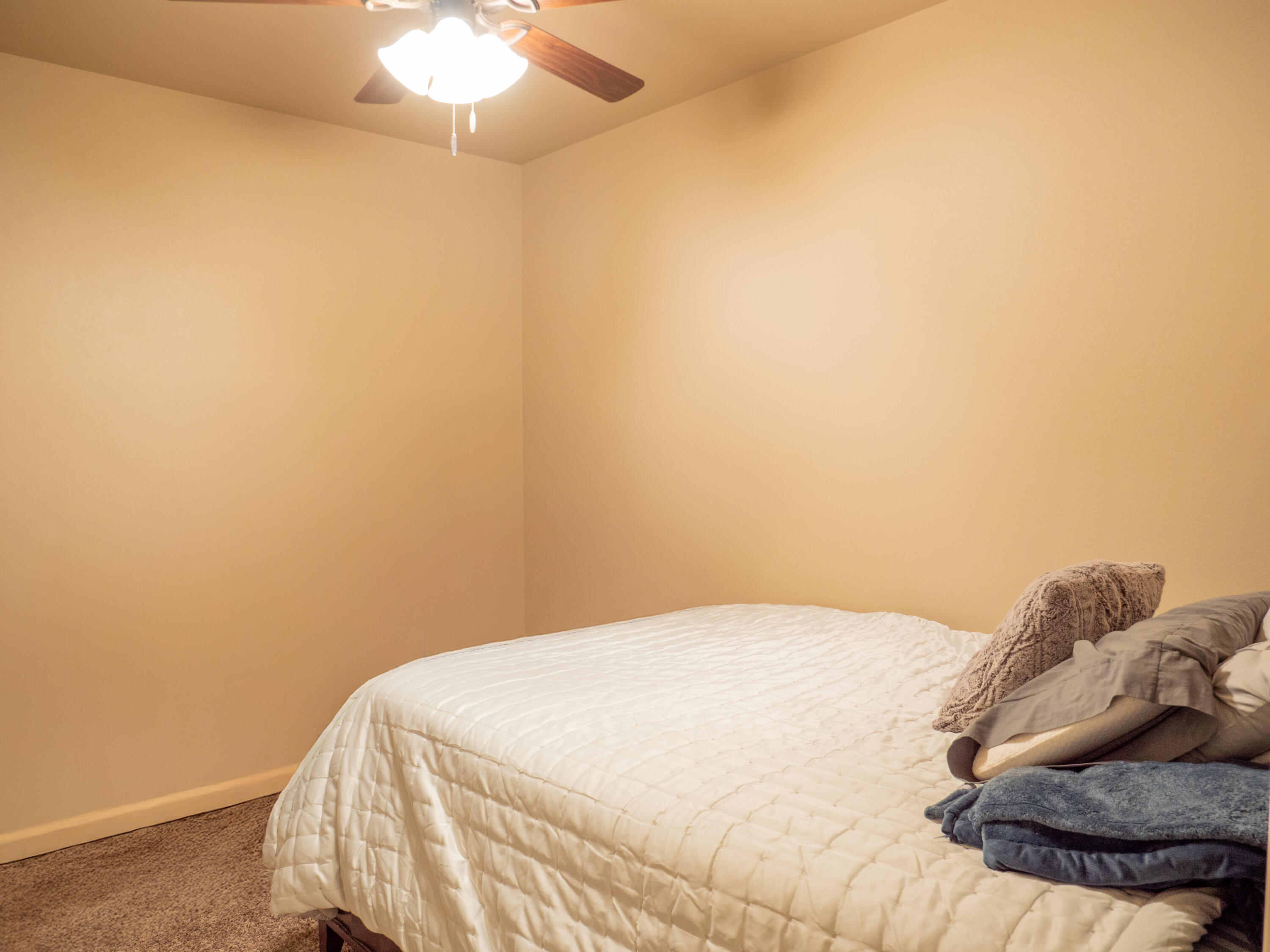 910 12th Street Wolfforth, TX 79382 - Photo 14 of 18 a bedroom with a bed and a chandelier fan