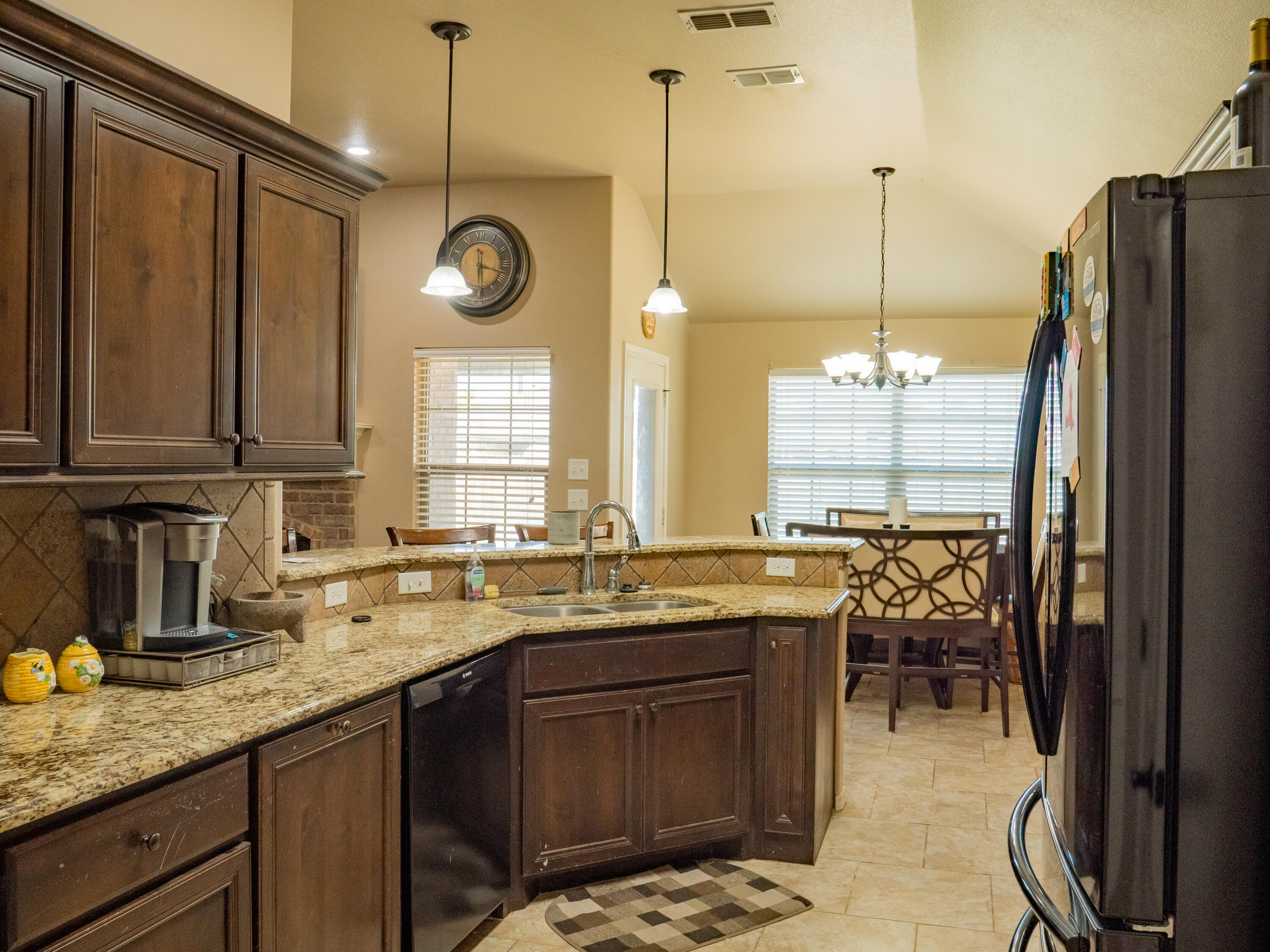 910 12th Street Wolfforth, TX 79382 - Photo 8 of 18 a kitchen with a sink a refrigerator a stove and wooden cabinets