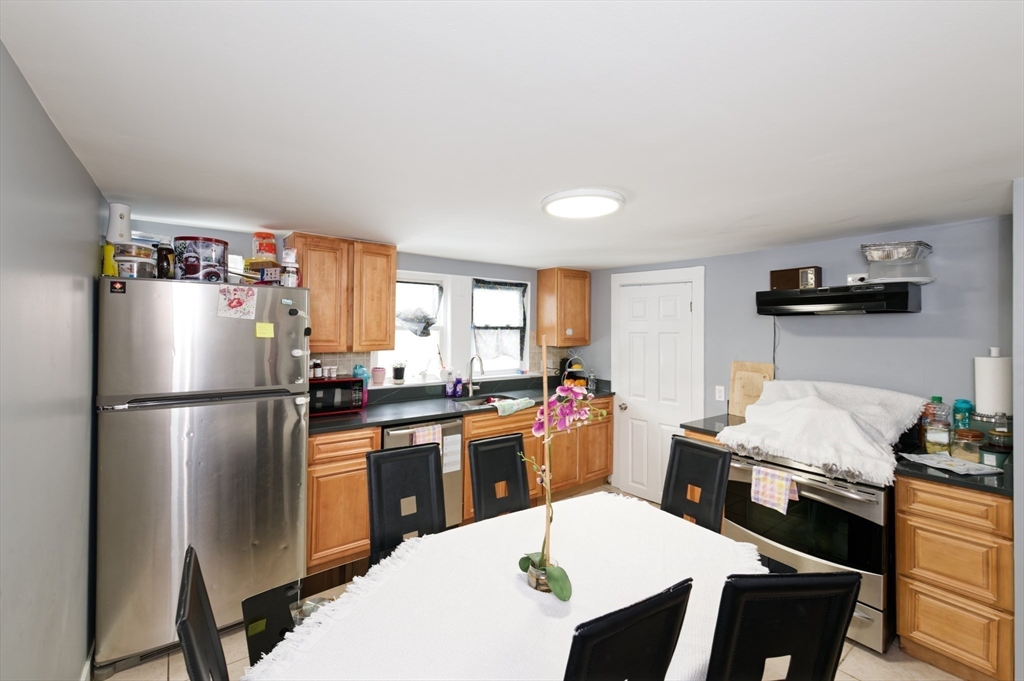 10 Rhubena Street Framingham, MA 01702 - Photo 20 of 30 a kitchen with a refrigerator a stove a sink a dining table and chairs