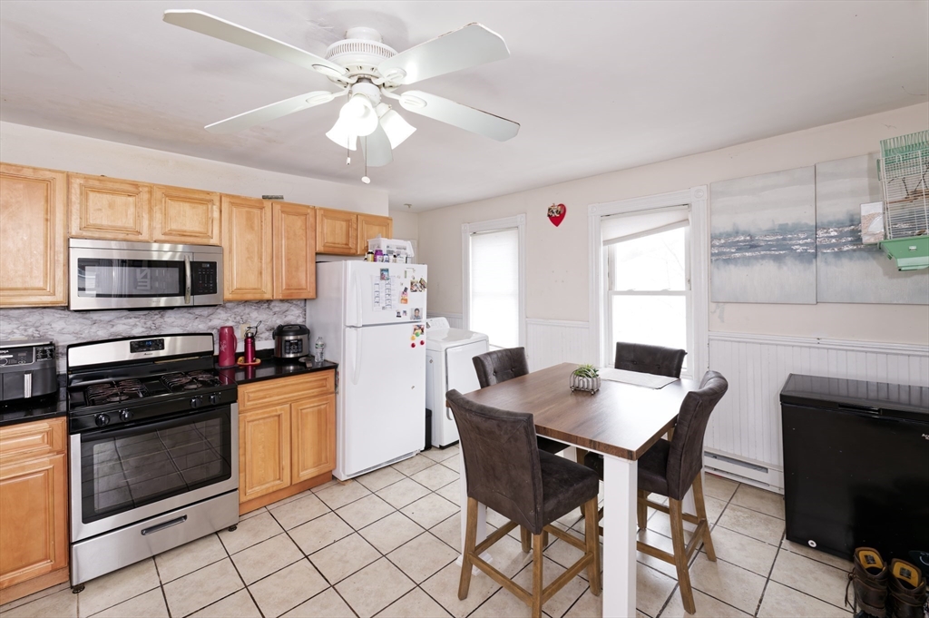 10 Rhubena Street Framingham, MA 01702 - Photo 7 of 30 a kitchen with granite countertop a stove a sink dishwasher a dining table and chairs with wooden floor