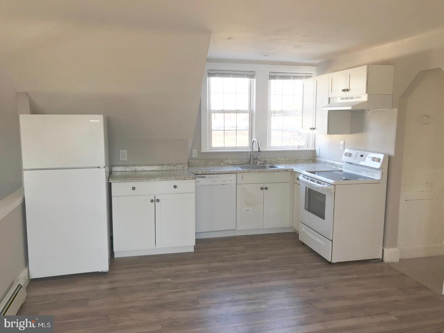 a kitchen with white cabinets sink and white appliances
