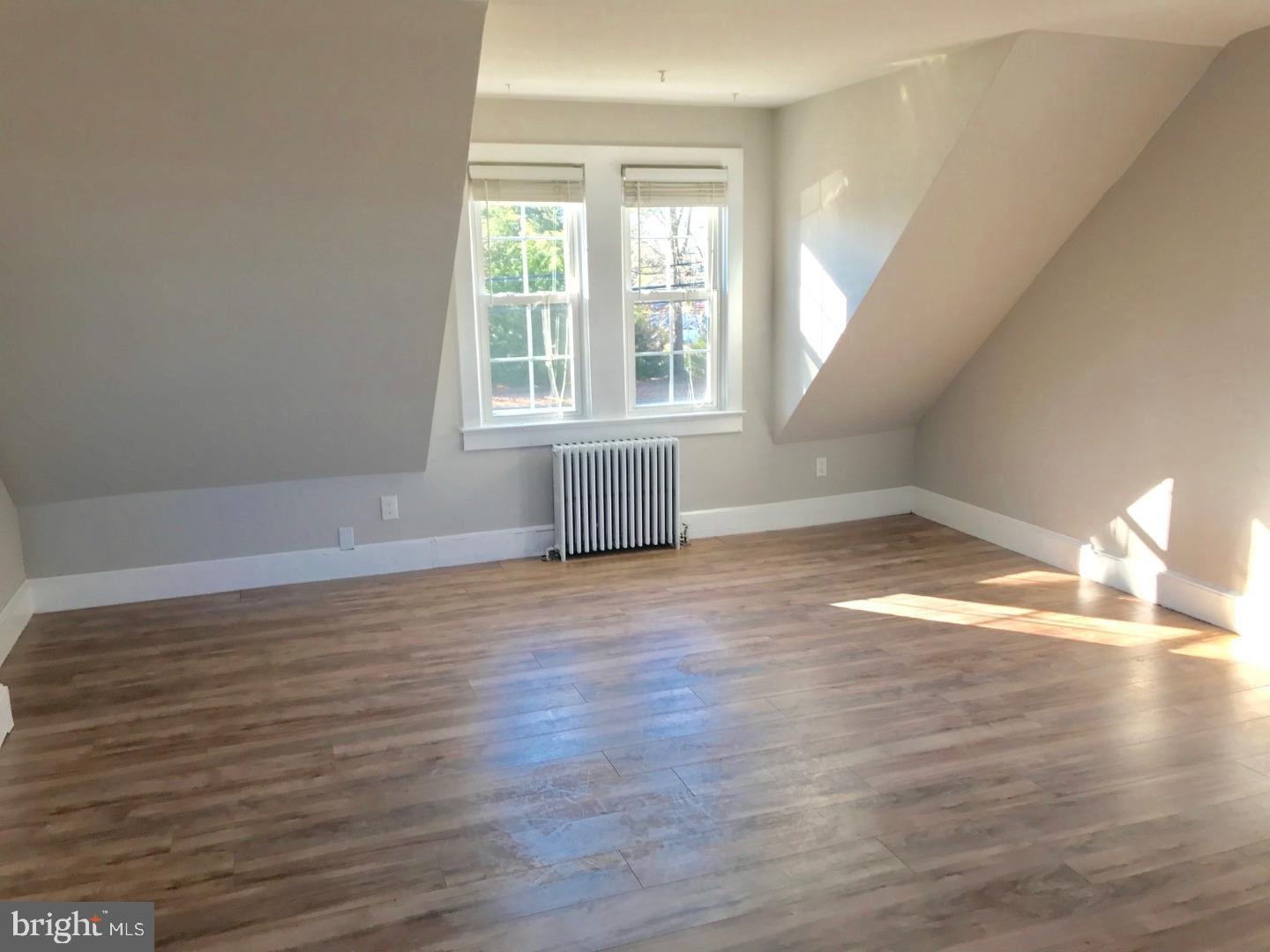 902 Hughes Drive, Unit 2 Hamilton, NJ 08690 - Photo 2 of 9 wooden floor in an empty room with a window