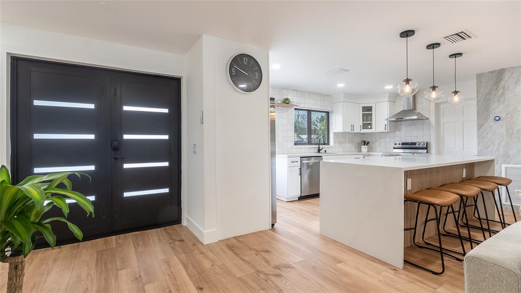 1399 West Camino Real Boca Raton, FL 33486 - Photo 2 of 45 a kitchen with stainless steel appliances granite countertop a refrigerator a sink a stove and a wooden floors