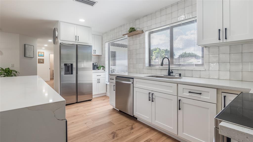 1399 West Camino Real Boca Raton, FL 33486 - Photo 6 of 45 a kitchen with white cabinets and white stainless steel appliances