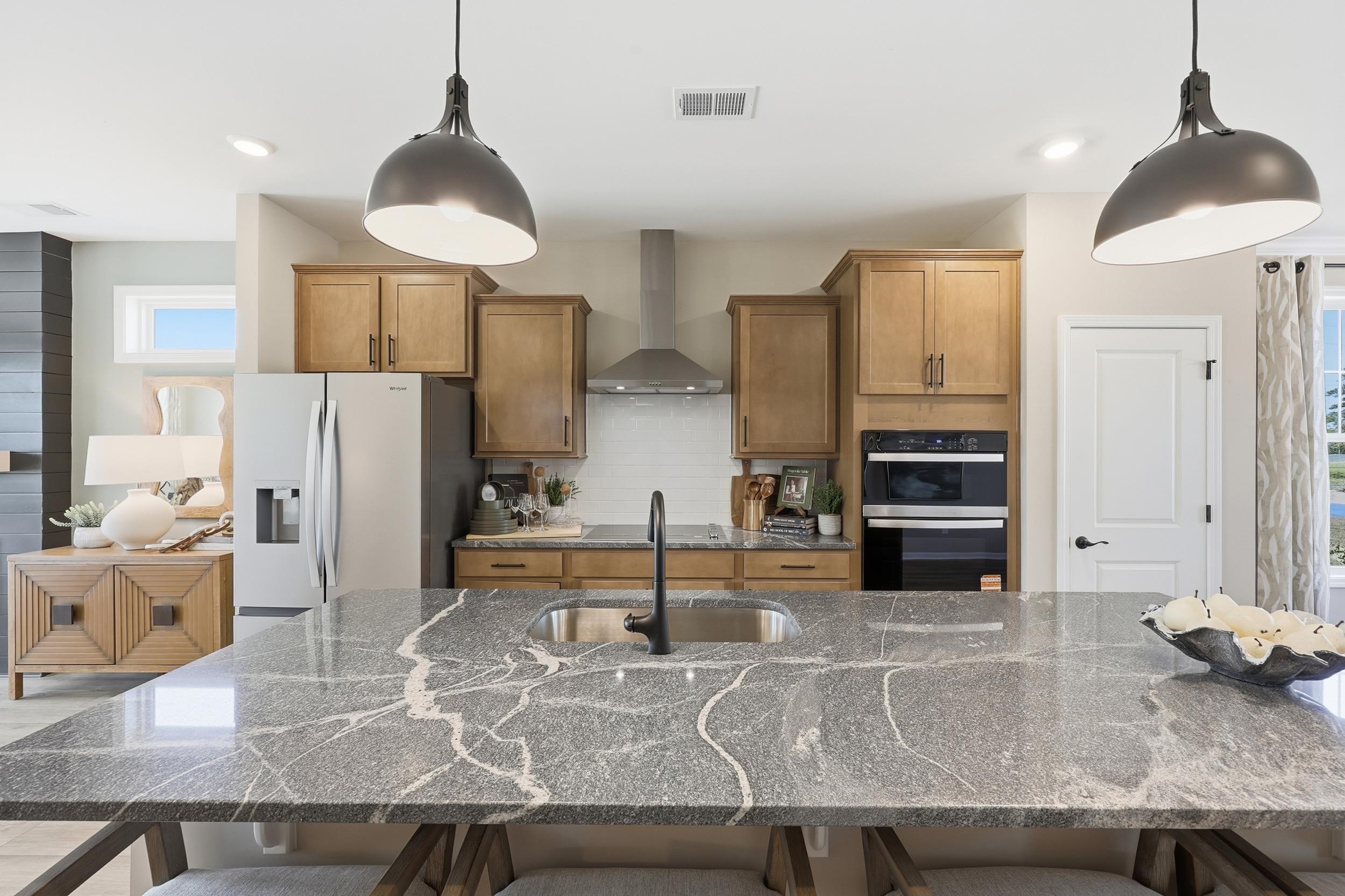 162 Westfield Circle Conway, SC 29526 - Photo 2 of 31 Kitchen featuring dark stone counters, a kitchen bar, wall chimney exhaust hood, and refrigerator with ice dispenser