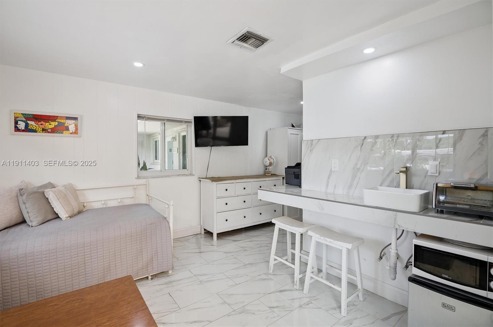 630 Northeast 175th Street Miami, FL 33162 - Photo 11 of 28 a living room with furniture and a flat screen tv